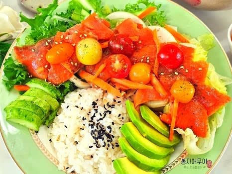 밥 한공기에 야채를 골고루 둘러주고 연어를 올리고 소스를 추가합니다.