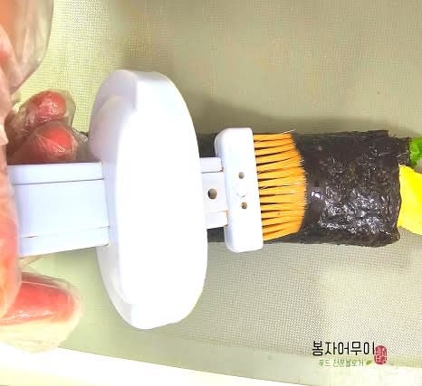 김밥을 단단히 말아서 참기름을 한 번 더 발라주세요.