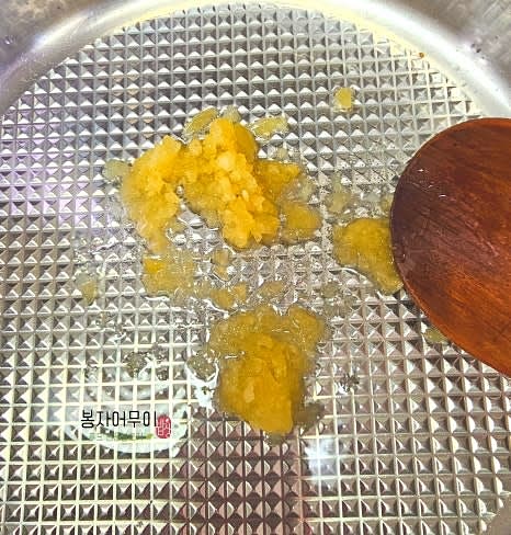 팬에 기름을 두르고 다진 마늘과 멸치를 볶아줍니다.