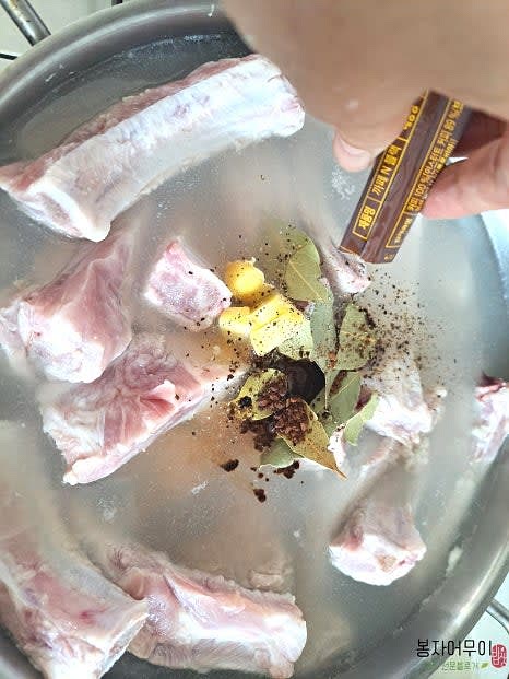 물에 월계수잎, 소주, 생강, 커피를 넣고 끓인 뒤 등갈비를 넣어 초벌 삶기를 합니다.