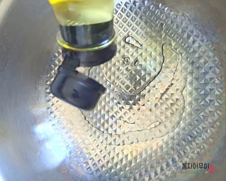 프라이팬에 콩기름 2스푼을 두르고 팝콘용 옥수수 60g을 넣습니다.