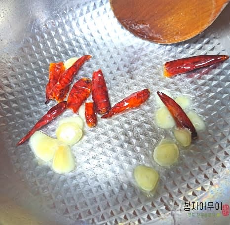 센 불에 기름을 두르고 마늘을 볶다가 태국 고추를 추가합니다.
