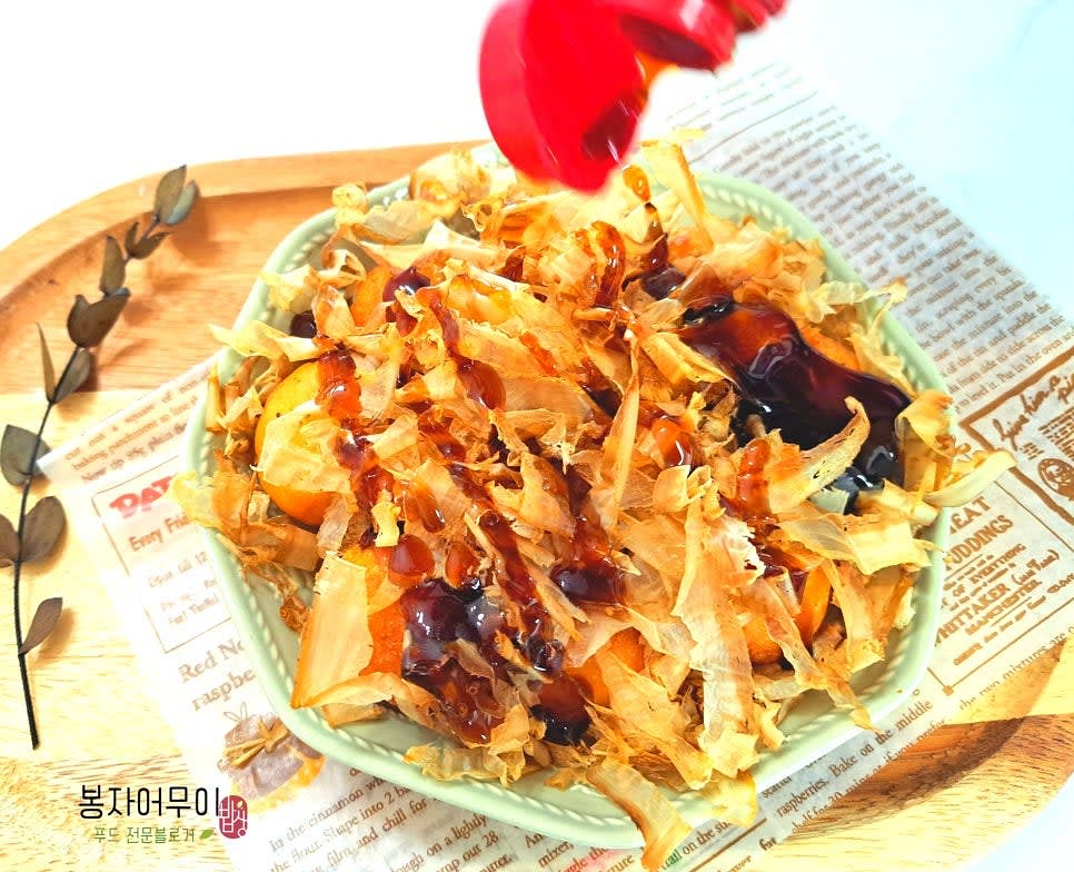 취향에 따라 데리야키 소스와 마요네즈를 타코야키 위에 뿌립니다.