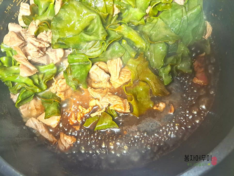 살짝 익은 소고기와 미역을 한쪽으로 밀어 넣고 빈 공간에 국간장 6스푼을 넣어 끓어오르면 물을 1.8L 부어줍니다. 참치 액젓 1스푼을 사용하시면 좀 더 깊은 맛을 내줍니다.