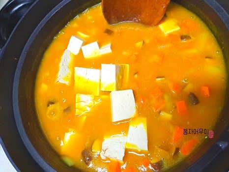 야채가 보글보글 끓어오르면 개어 둔 카레 가루를 넣고 섞은 후 두부를 추가합니다.