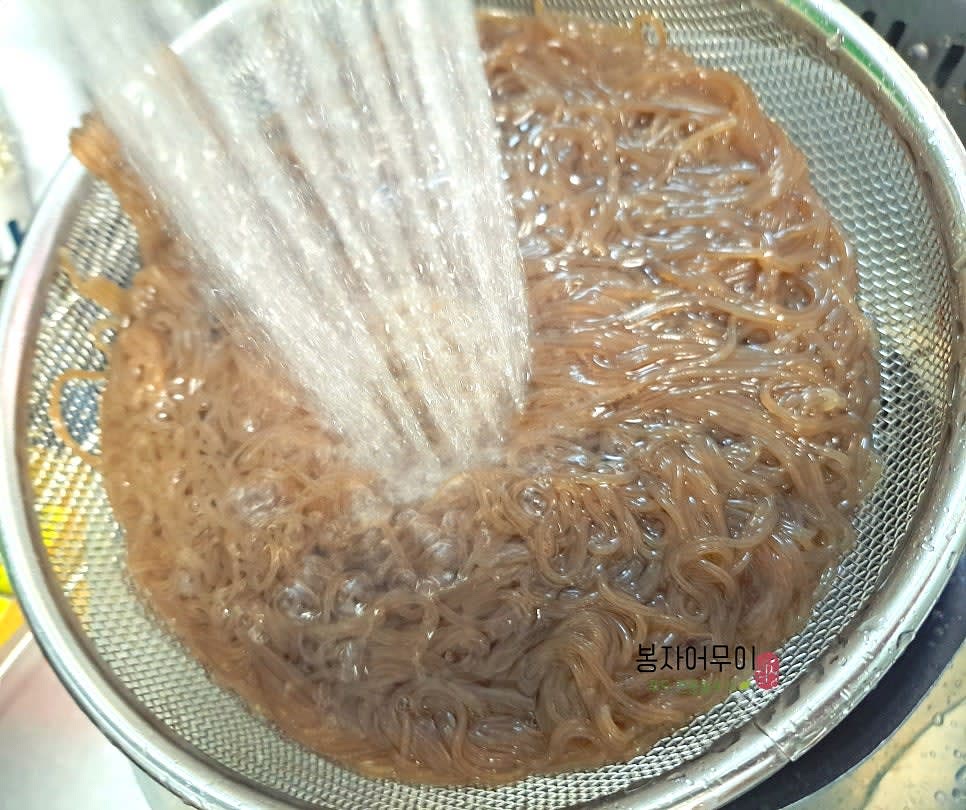 삶은 냉면을 찬물에 헹궈 면의 끈적함을 제거합니다.