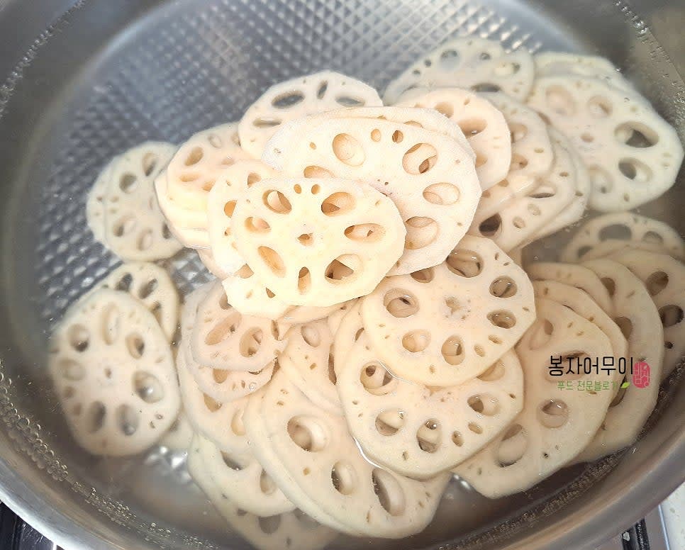 연근 2개 중 2개를 깨끗이 세척하여 껍질을 벗기고 얇게 썰어 줍니다. 갈변이 되지 않도록 바로 물에 담그고 식초 2스푼 정도 섞어주세요.