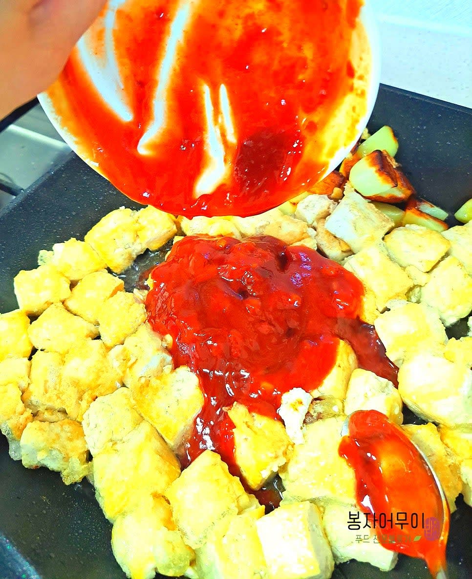 두부가 앞뒤로 노릇노릇 구워지면 강정 소스를 부어줍니다.