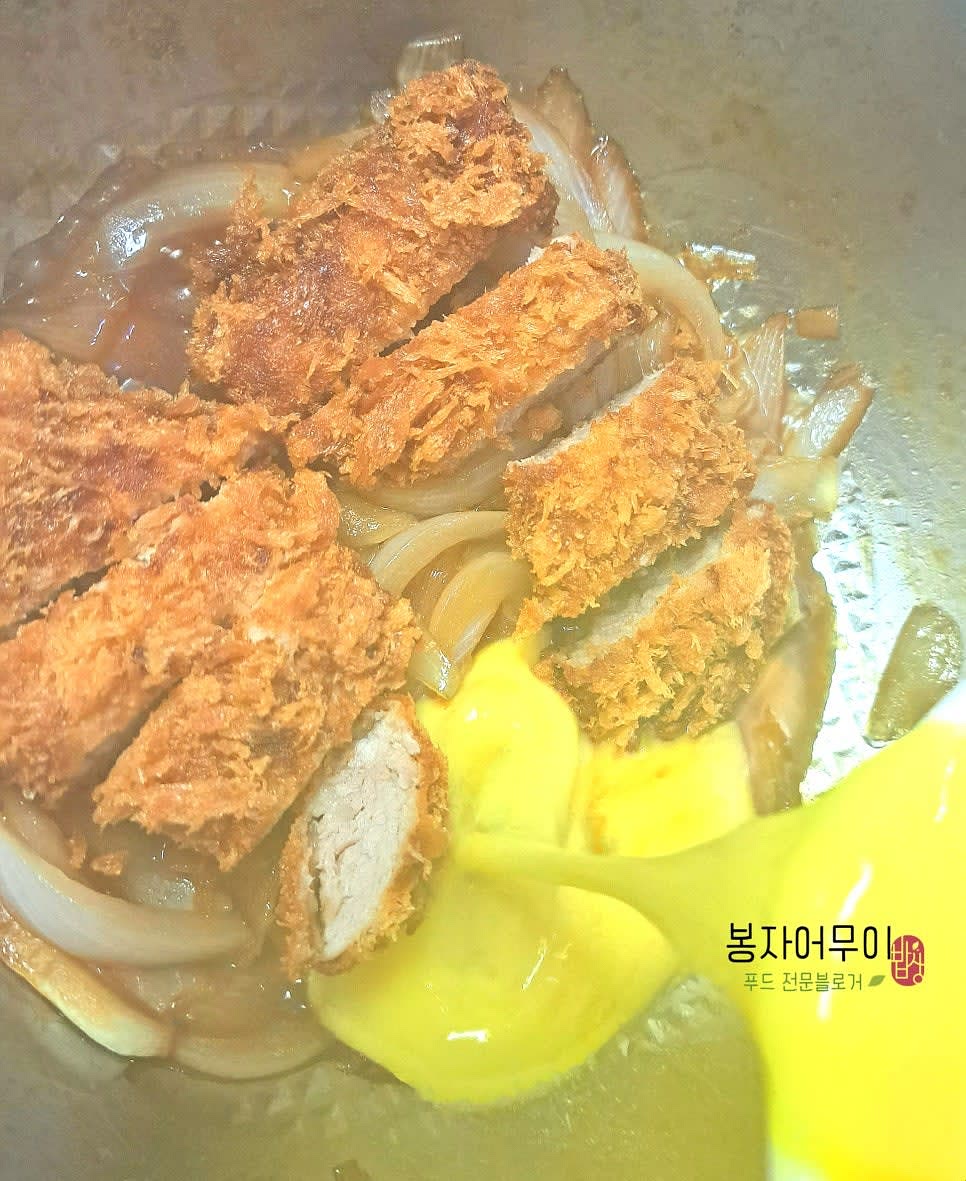 볶은 양파에 돈가스를 올리고 소스를 부은 후 풀어놓은 계란물을 부어 줍니다.