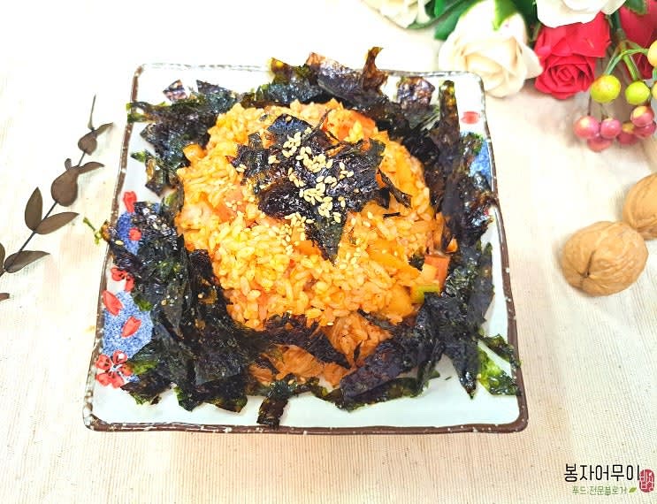 필요에 따라 굴 소스를 추가해 간을 맞추고, 완성된 김치볶음밥을 그릇에 담아냅니다.