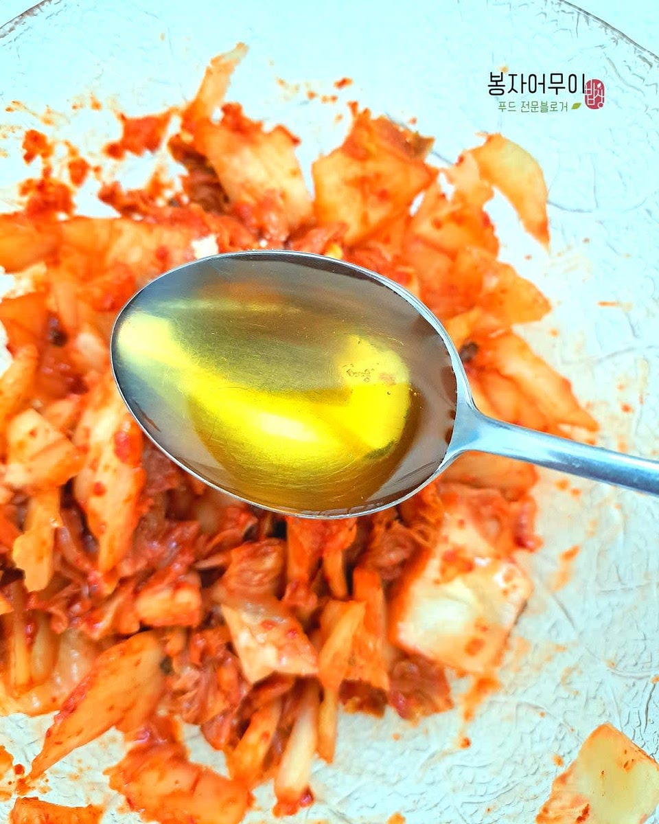 묵은지를 잘게 썰고 설탕과 참기름을 넣어 섞어줍니다.