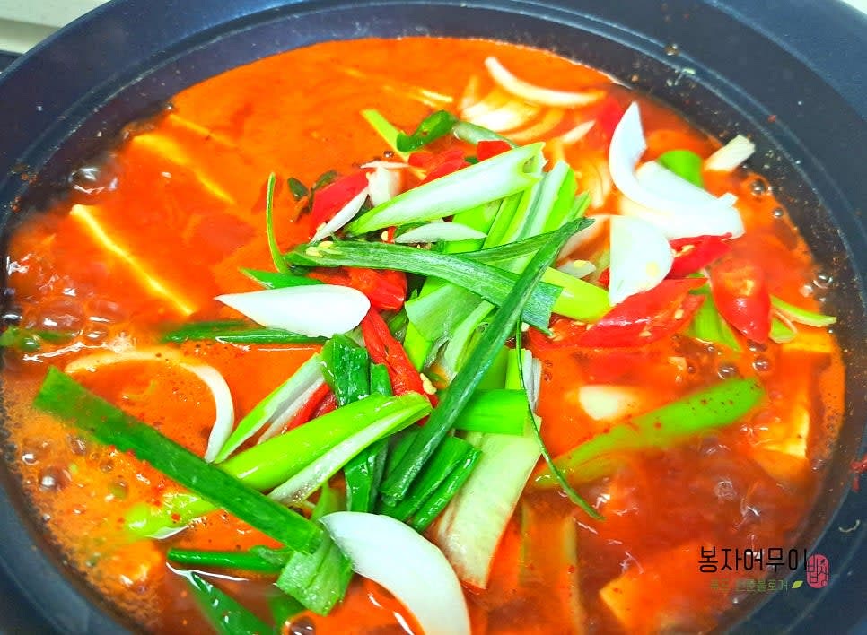 두부가 끓어오르면 야채를 넣고 다시 끓여주세요. 두부 속에 양념이 빨갛게 스며 들어야 합니다.