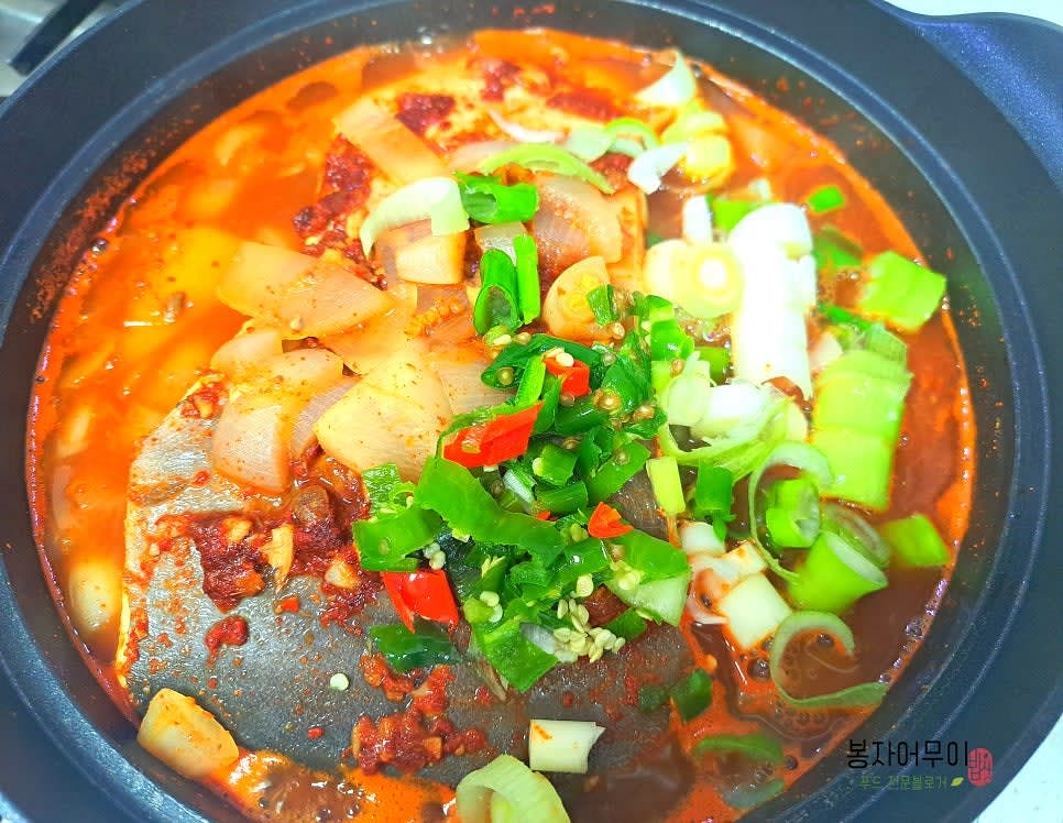 무가 빨갛게 물들면 남은 양념 1/3을 마저 넣고 대파와 청양고추를 넣어주고 조금 더 끓여줍니다.