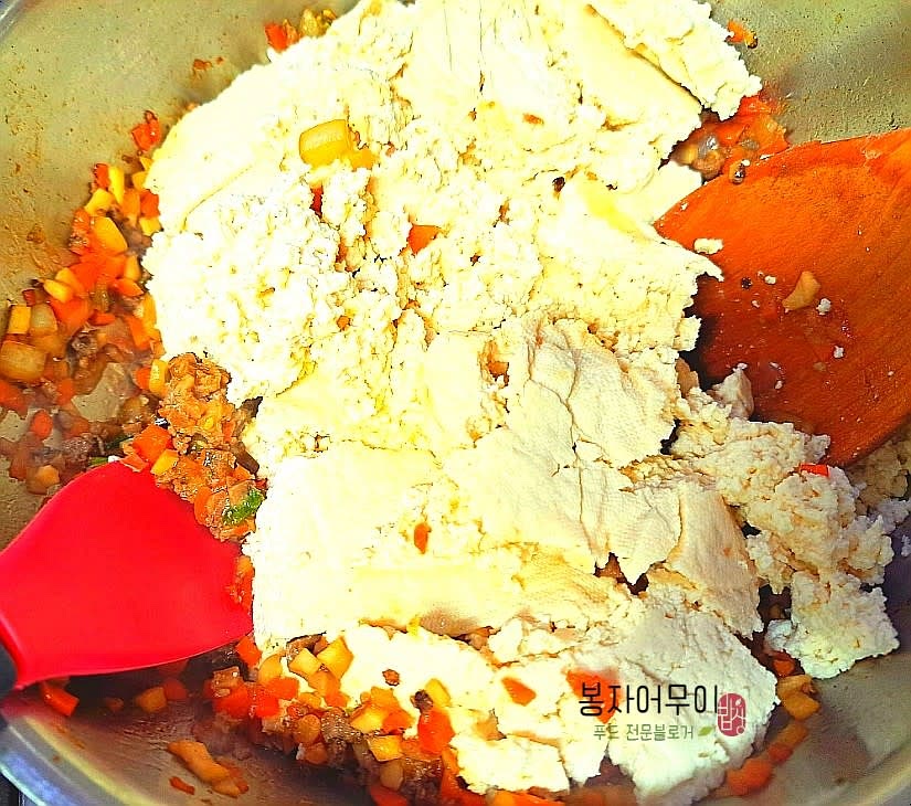 소고기소보로를 두부와 함께 팬에 넣고 참기름 한 스푼과 양념을 추가하여 살짝 볶아주세요.