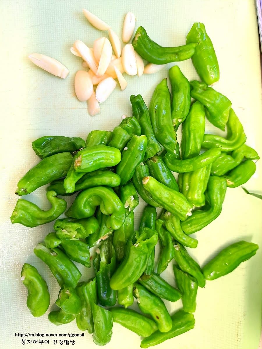 꽈리고추와 마늘의 꼭지를 따고 깨끗이 세척해서 멸치와 비슷한 길이로 자릅니다. 마늘은 얇게 편 썰어줍니다.