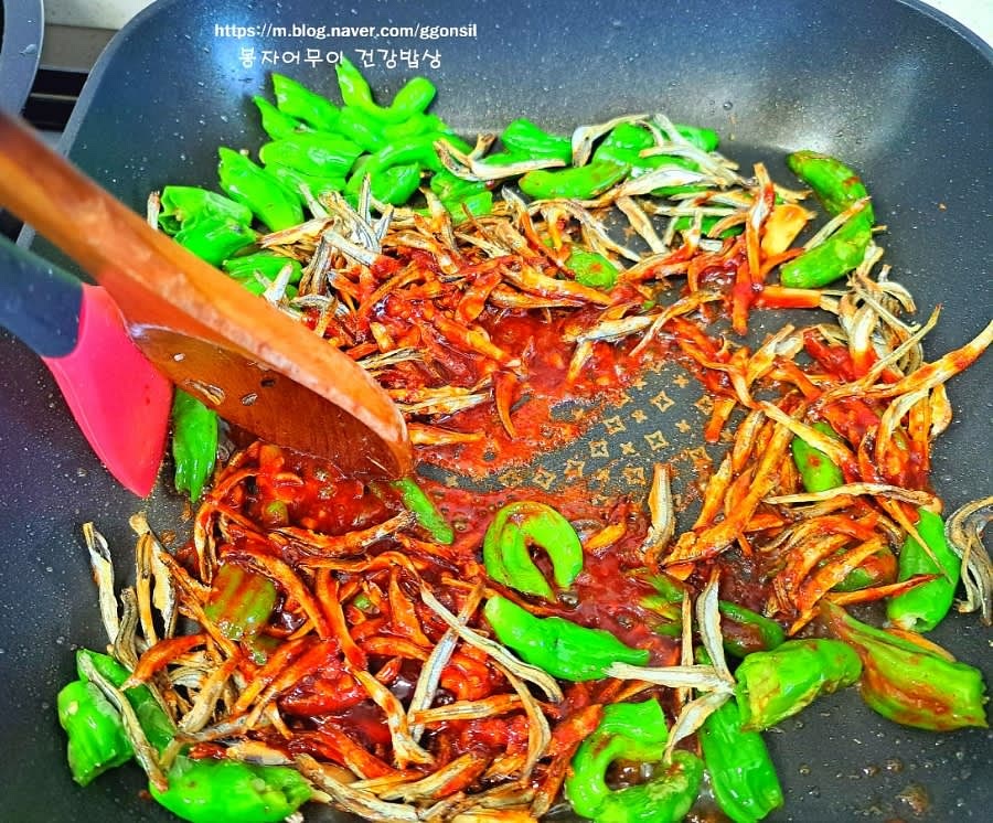 양념장을 멸치와 함께 넣고 잘 섞어줍니다. 참기름과 들기름을 각각 한 스푼씩 넣어 고소한 맛을 더합니다.