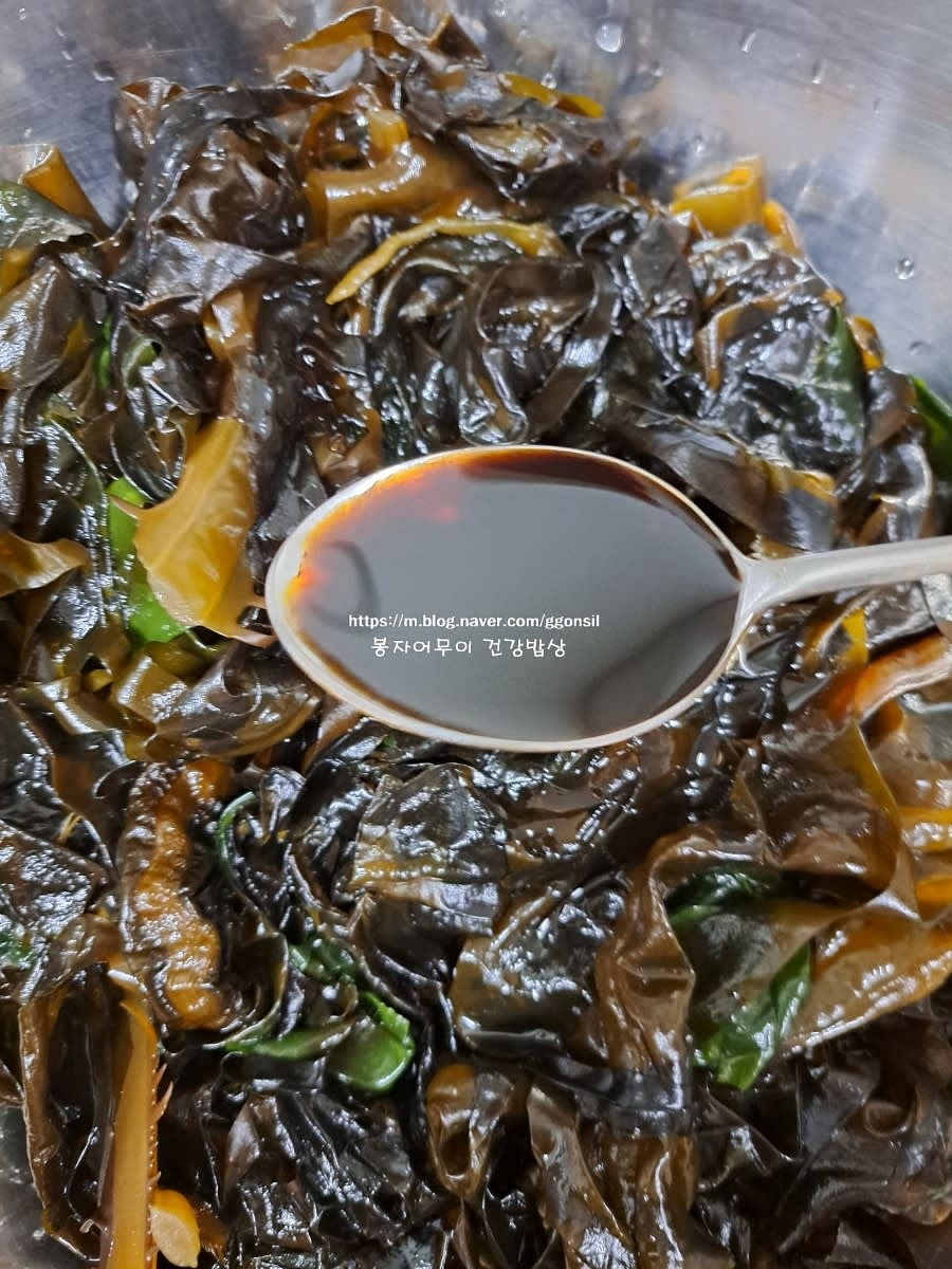 물기를 제거한 물미역에 국간장 2스푼, 참치 액젓 2스푼, 다진 마늘 1스푼을 넣고 무칩니다.