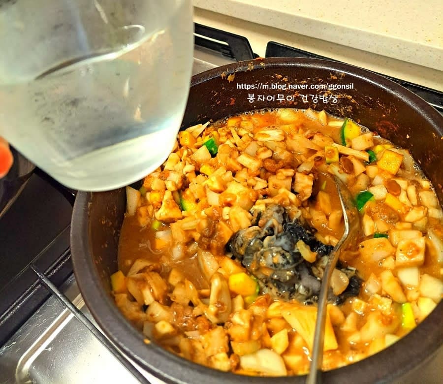 뚝배기에 된장, 멸치가루 섞은 것과 야채, 우렁이를 올리고 참기름 1스푼을 두르고 약불에 볶아 줍니다. 숨이 좀 죽었을 때 물 1컵을 부어 졸아들 때까지 끓입니다.