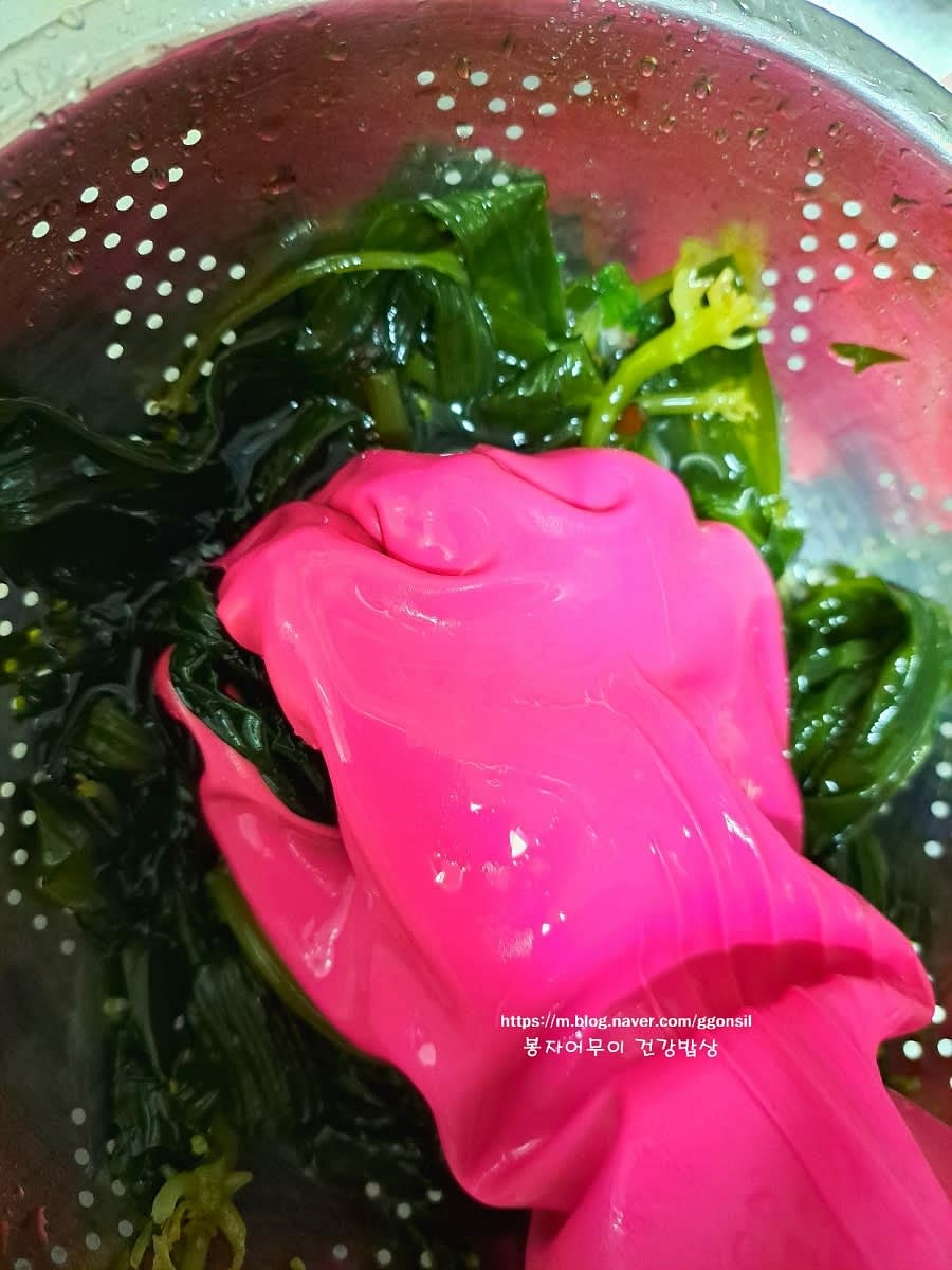 데친 곰피를 흐르는 물에 여러 번 치대면서 씻어줍니다.