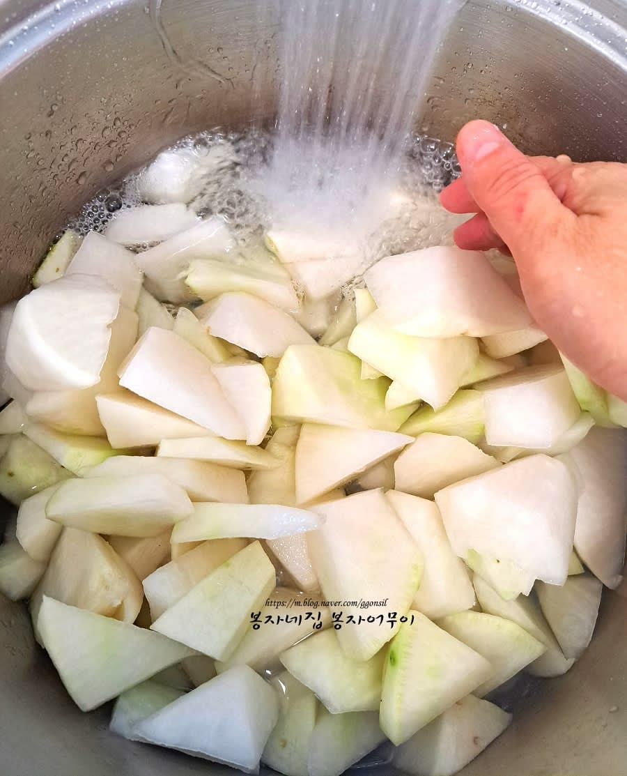 절인 무를 흐르는 물에 헹궈서 물기가 빠질 수 있도록 체반에 받쳐둡니다.