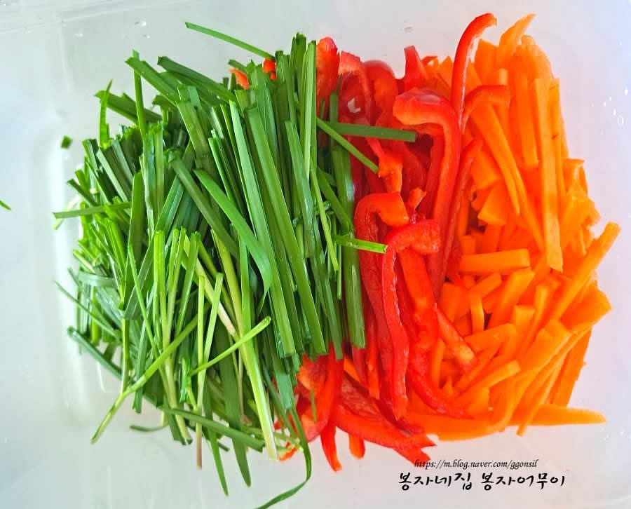 파프리카와 당근은 꼭지를 제거한 뒤 얇게 채썰고, 부추와 양파도 같은 크기로 채썰어 준비합니다.