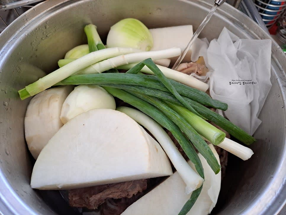 큰 냄비에 갈비, 무, 대파, 양파, 생강, 마늘, 다시마, 한약재를 넣고 물을 가득 부은 후 끓입니다. 생강 맛술도 추가합니다.