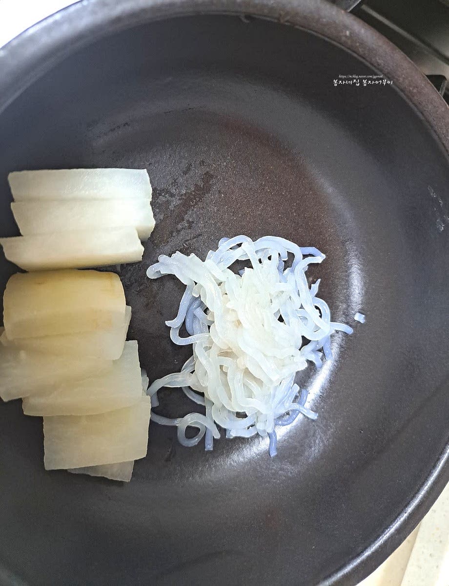 완성된 갈비탕을 뚝배기에 담고 건져둔 무를 썰어 놓은 것과 지단, 당면을 넣고 국물을 덜어줍니다.