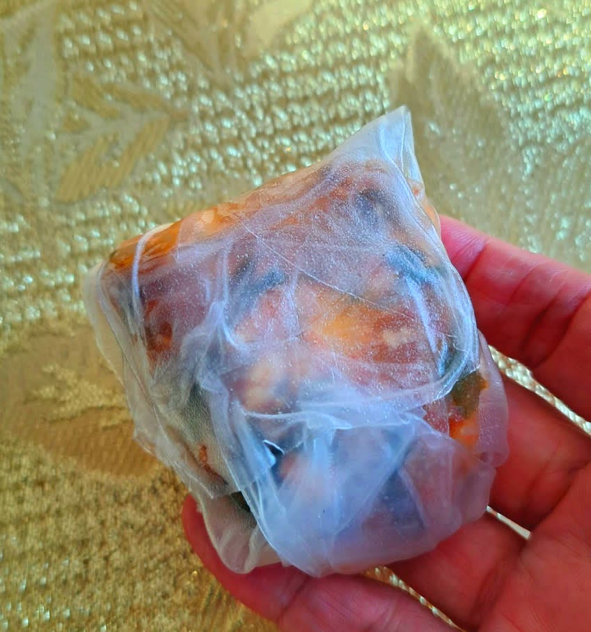 라이스페이퍼 위에 만든 속을 올리고 잘 감싸서 만두 모양으로 만드세요.