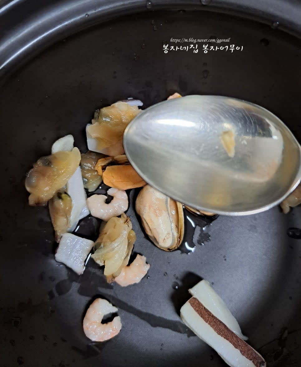 냉장고 속 해물믹스를 꺼내 한 줌을 뚝배기에 넣고 맛술부터 넣습니다.