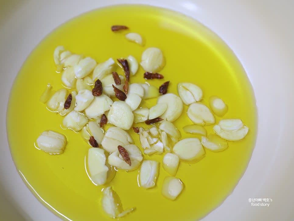 통마늘 20알은 칼등으로 살짝 으깨 넣습니다. 페페론치노도 추가합니다.