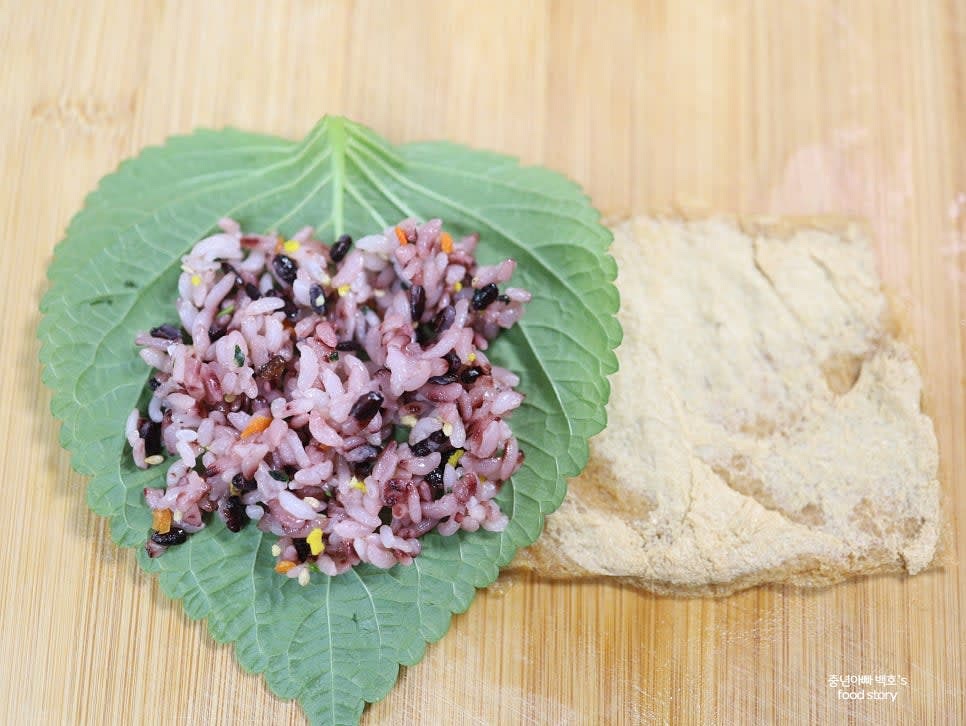 김 위에 밥을 얇게 깔고, 그 위에 깻잎을 올립니다.
