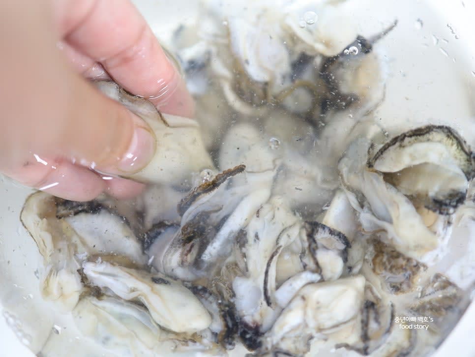 손으로 굴을 하나씩 만지며 껍질이나 이물질이 붙어 있는지 확인합니다. 발견된 이물질은 부드럽게 문질러 제거합니다.