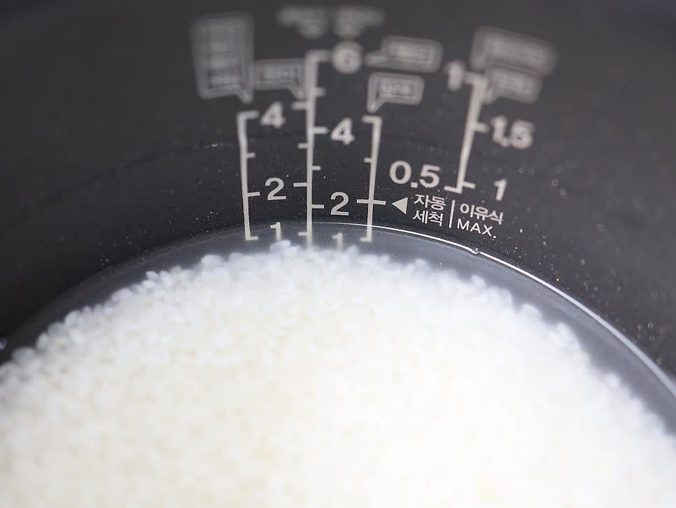 흰쌀은 계량컵으로 2컵 정도 깨끗이 씻어 주세요. 씻은 쌀을 전기밥솥에 바로 넣어 주세요. 쌀 2컵 기준으로 물을 1.5컵 넣어 주세요. 평소보다 조금 적게 잡아 주세요.