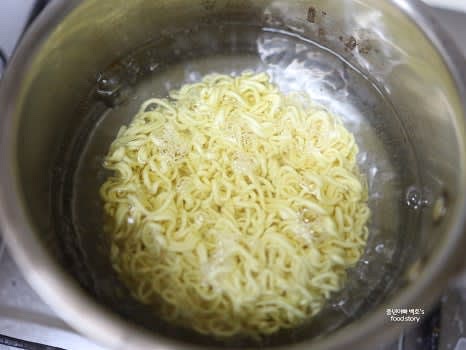 라면은 끓는 물에 1분간 삶아 면만 건져 팬에 넣어주세요.