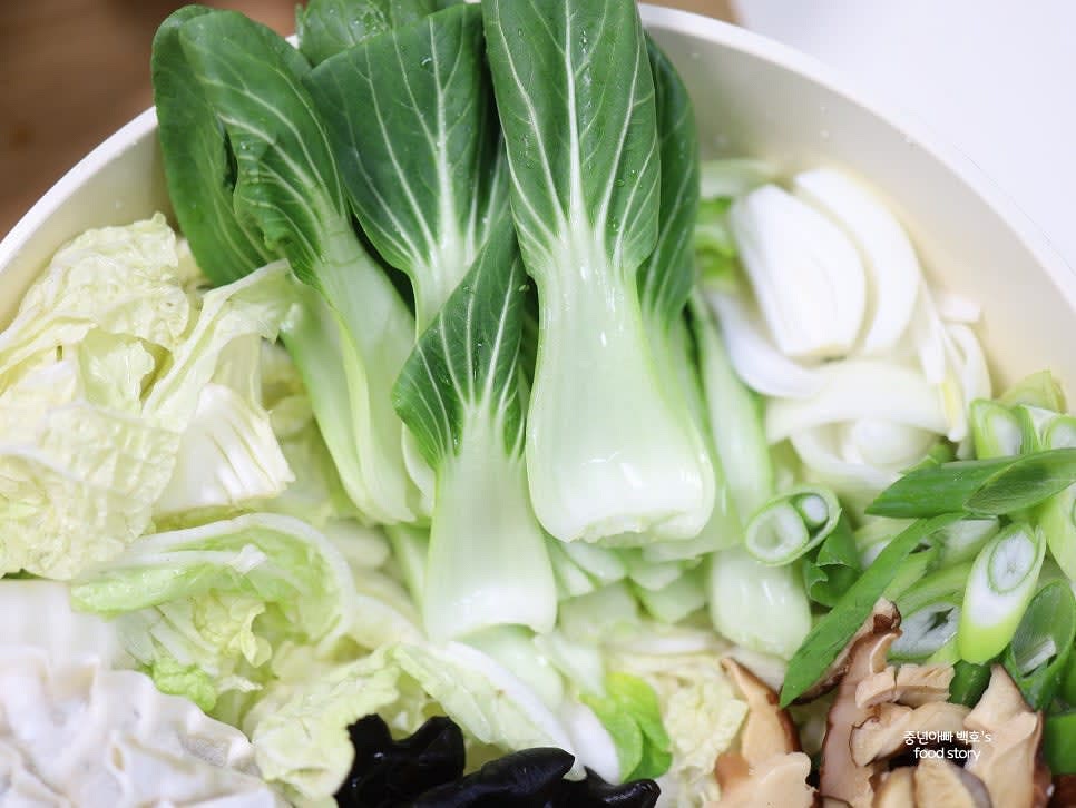 냄비 바닥에 배추를 한 겹 깔고, 그 위로 배추, 청경채, 양파, 대파를 순서대로 올립니다.