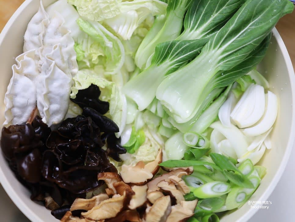 불려둔 목이버섯과 표고버섯을 듬뿍 올리고, 냉동 만두 4알을 추가합니다.