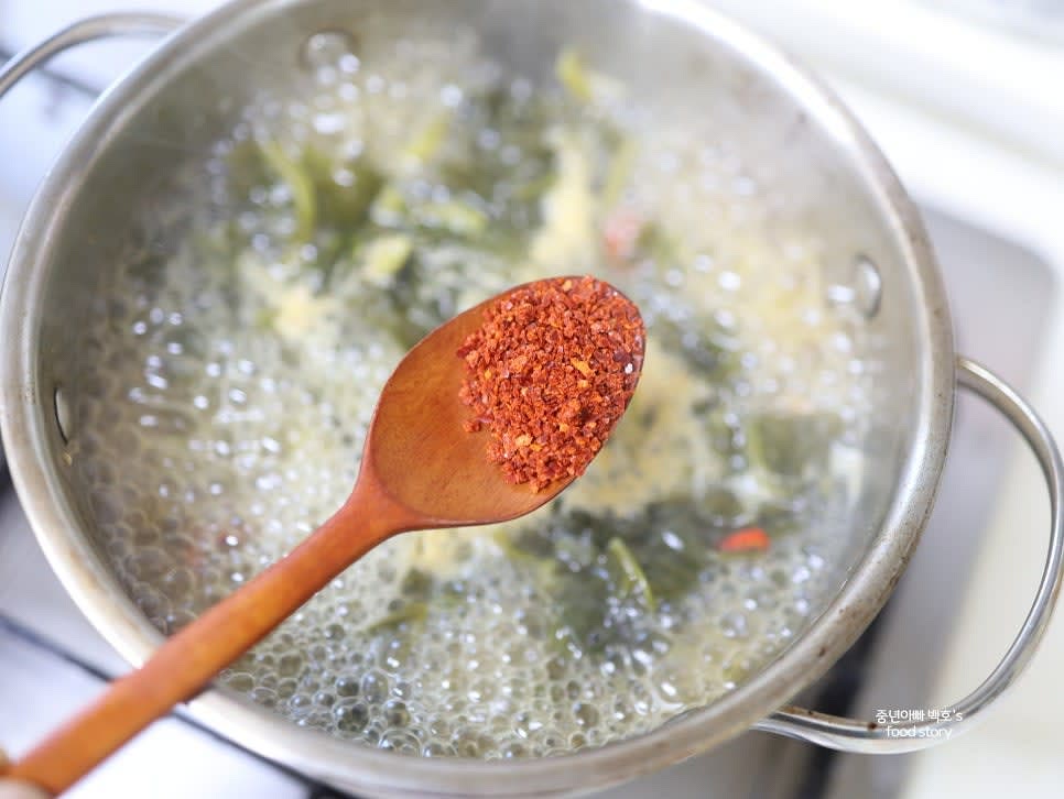 시금치 된장국을 다시 끓이고 팔팔 끓으면 고춧가루 1/2스푼과 다진 마늘 1/2스푼을 넣습니다.