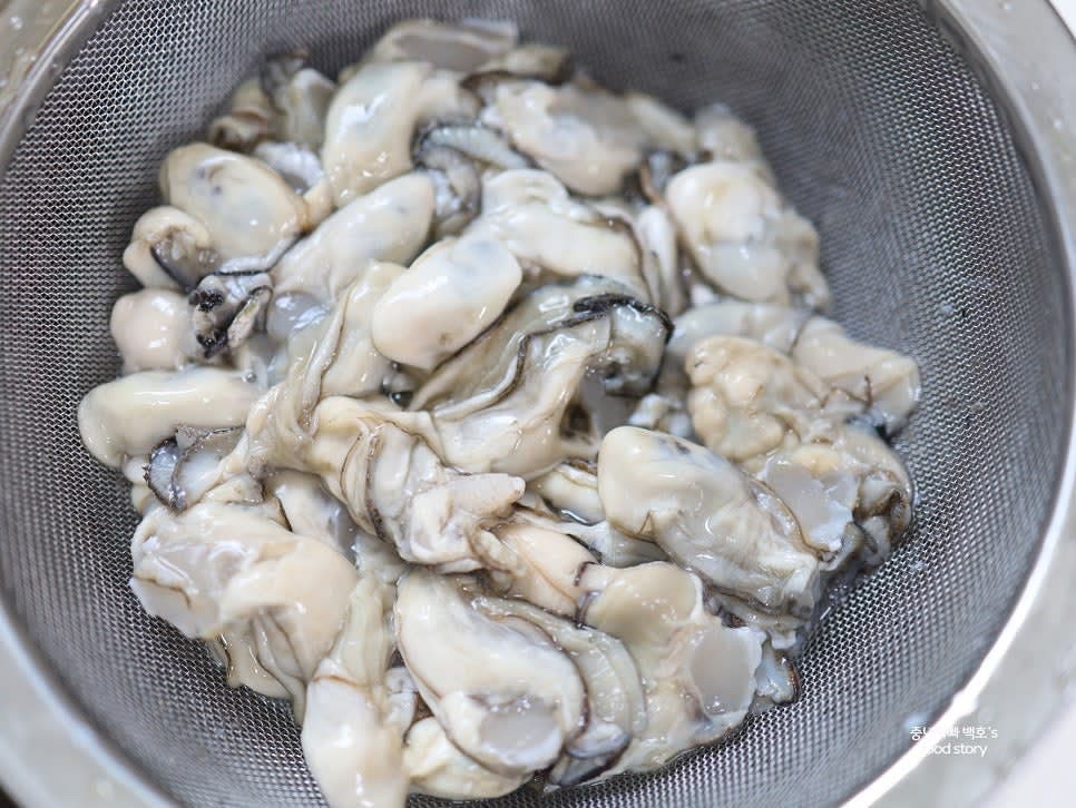 손으로 굴을 살펴 껍질이 묻어 있는지 확인한 뒤 흐르는 물에 한 번 더 세척합니다. 세척한 굴을 채반에 밭쳐 물기를 제거합니다.