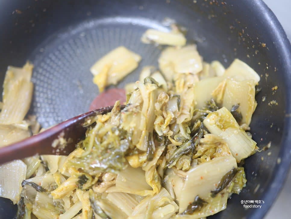 팬에 들기름 3스푼을 넣고 묵은지를 넣어 볶아주세요. 수분기가 줄어들 때까지 볶아줍니다.