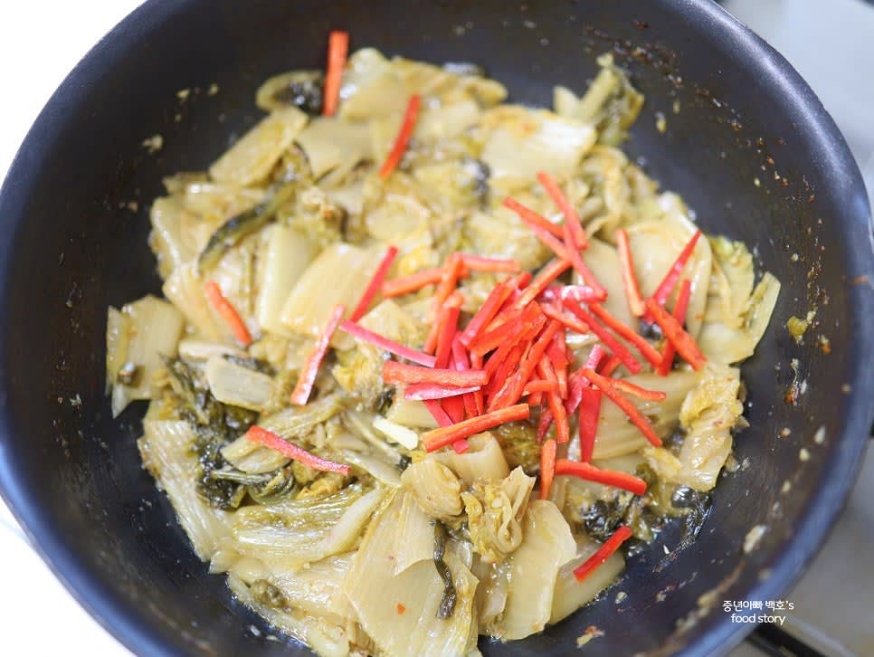 홍고추를 마지막에 넣어 색감을 살려줍니다. 먹음직스럽게 완성된 묵은지 들기름 볶음을 접시에 담아주세요.