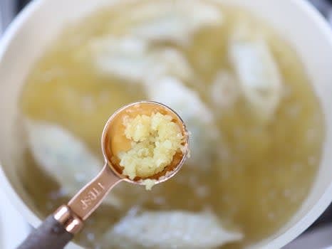 떡과 만두가 익으면 다진 마늘 1/2스푼과 대파를 넣어주세요. 추가 간은 참치 액젓 1/2스푼을 넣어 간을 맞춰 주세요.