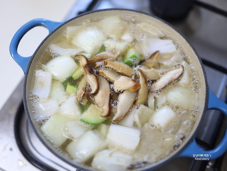 육수가 팔팔 끓으면 양파, 애호박, 표고버섯을 넣고 끓입니다.