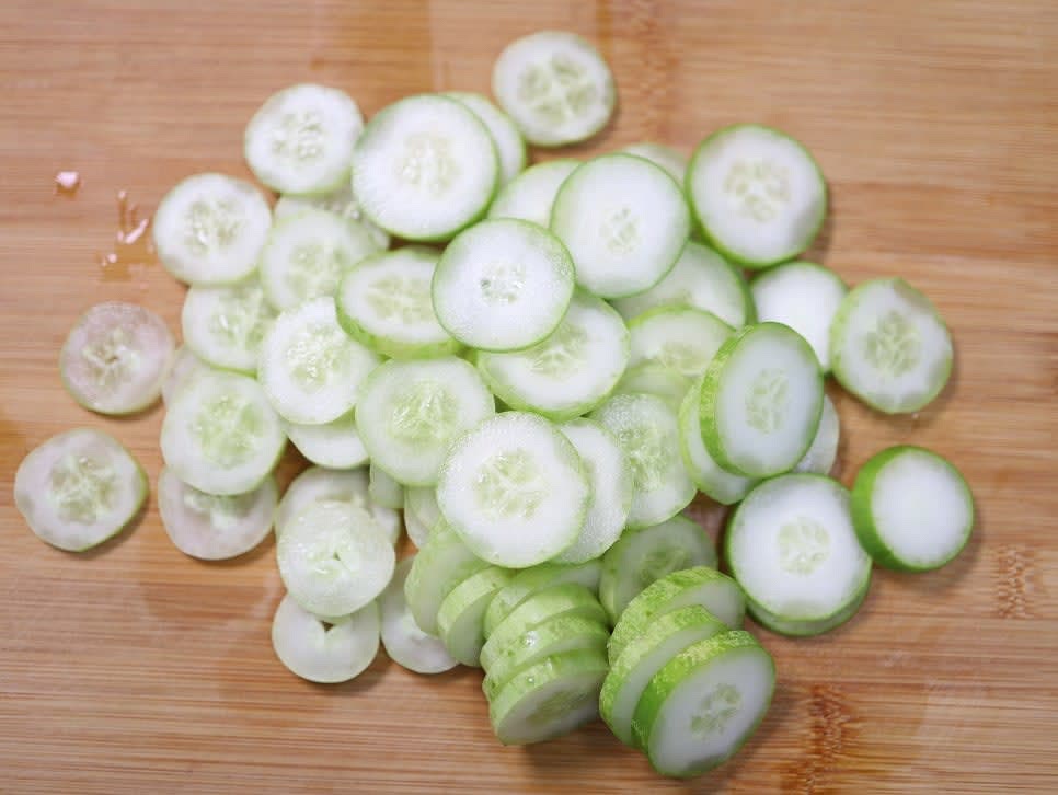 오이를 깨끗이 씻은 후 껍질째 사용하기 위해 소금으로 문질러 주세요. 흐르는 물에 깨끗이 헹궈준 후 0.2cm 두께로 채썰어 주세요.