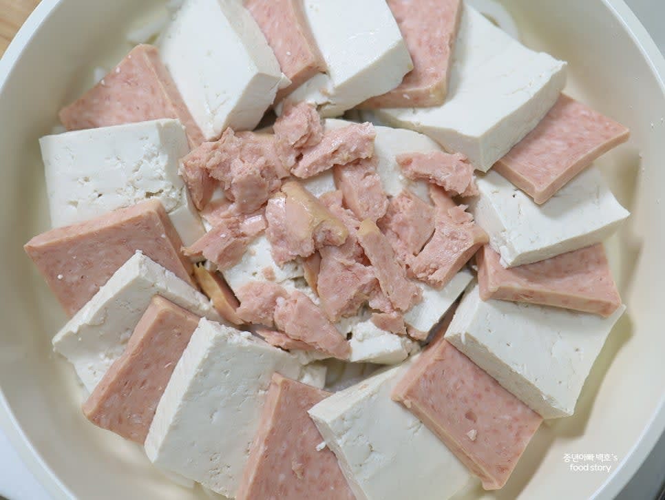 두부와 스팸을 번갈아 가면서 반씩 겹치게 팬에 놓아줍니다.