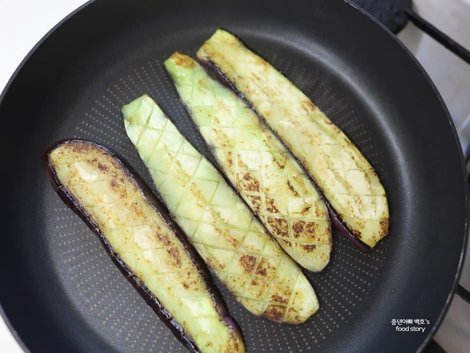 팬에 기름을 두르고 칼집 낸 가지를 구워줍니다. 칼집 낸 면이 바닥을 향하게 놓고 노릇하게 익힌 후 뒤집어 구워줍니다.