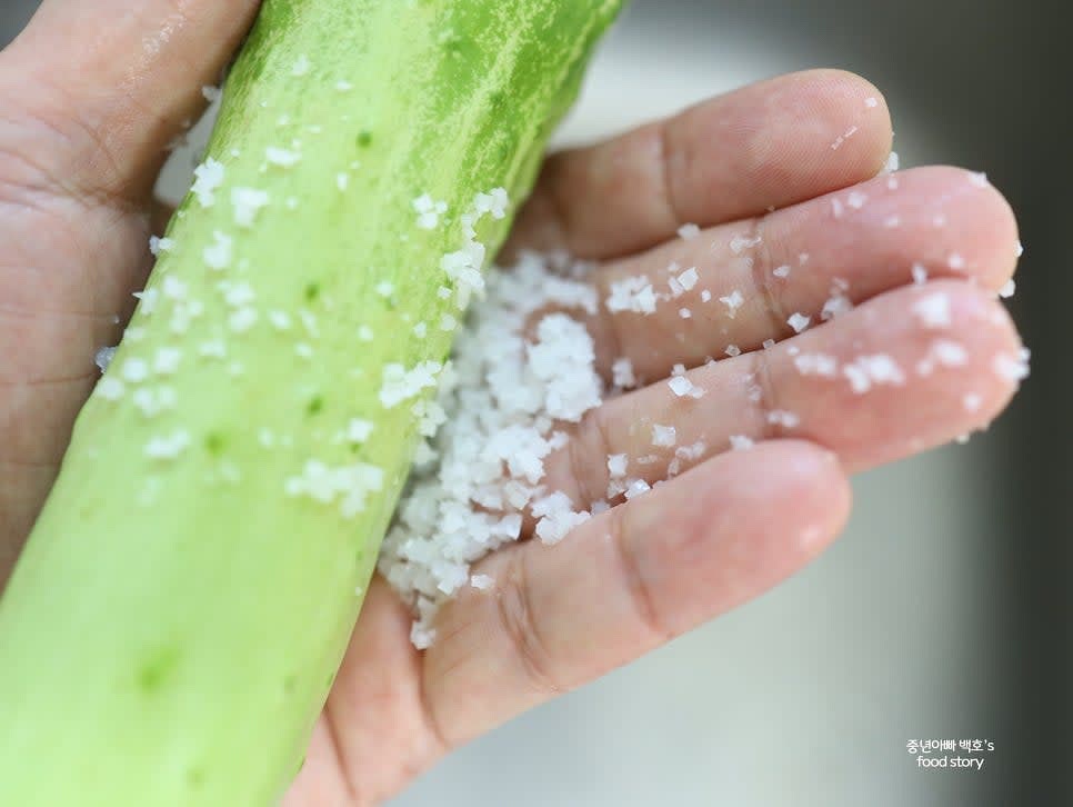 오이를 흐르는 물에 씻은 후 굵은 소금으로 문질러 껍질을 닦아 줍니다. 키친타월로 물기를 제거합니다.