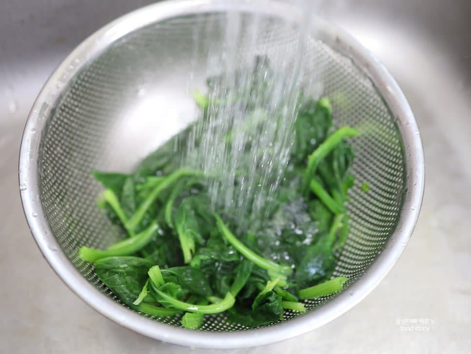 데친 시금치를 찬물에 헹구어 잔열을 제거하고 물기를 손으로 꼭 짭니다.