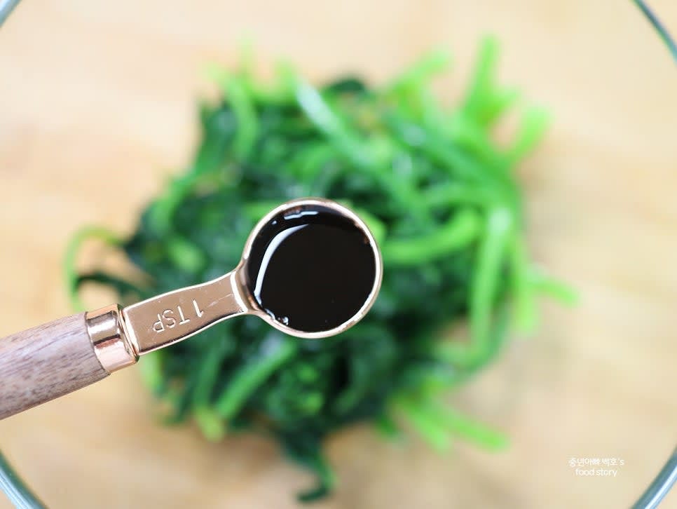 큰 그릇에 시금치를 담고 국간장 1티스푼을 넣어 손으로 조물조물 무칩니다.