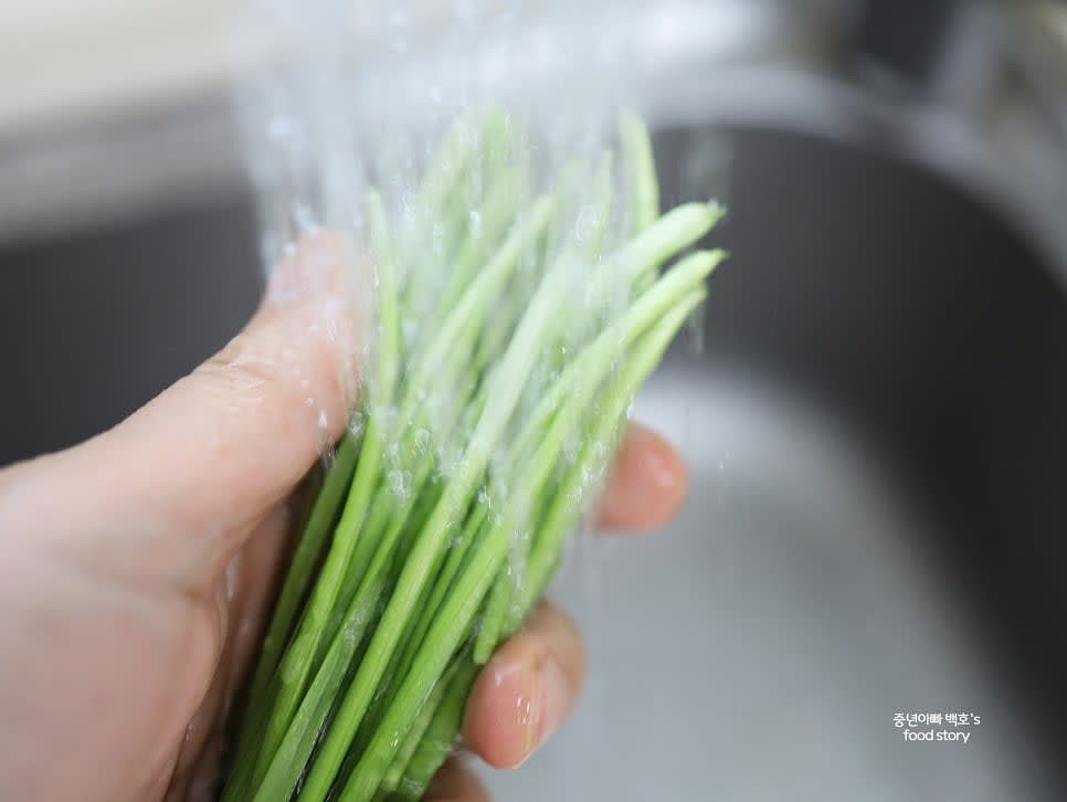부추를 깨끗이 손질하고 흐르는 물에 씻은 뒤, 시들거나 누렇게 변한 부분은 제거합니다.