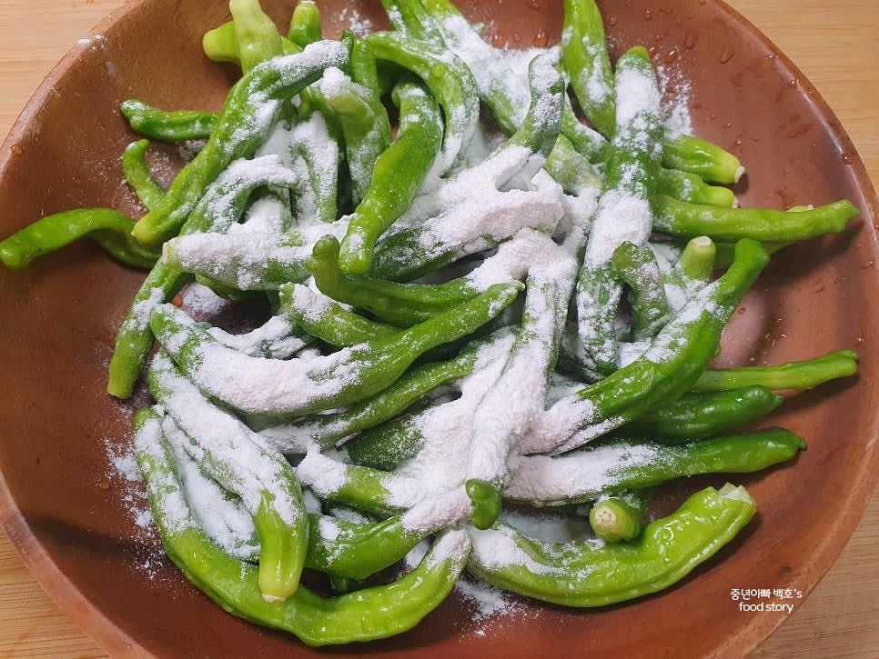 쌀가루 2숟가락을 꽈리고추에 넣고 골고루 묻도록 잘 버무립니다.